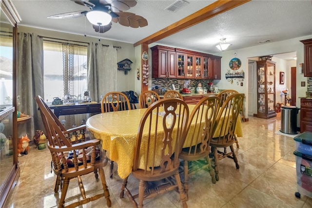 dining room featuring light tile patterned floors, a ceiling fan, visible vents, and bar area