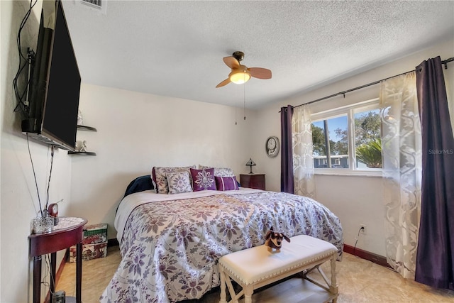 bedroom featuring baseboards, a textured ceiling, and a ceiling fan