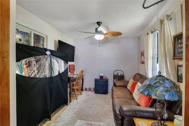 carpeted living area with a ceiling fan