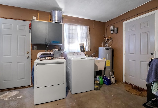 clothes washing area featuring washing machine and dryer, electric water heater, and cabinet space