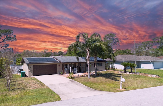 single story home featuring solar panels, a porch, driveway, a yard, and an attached garage