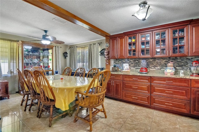 dining area featuring a textured ceiling, visible vents, beamed ceiling, ceiling fan, and light tile patterned floors