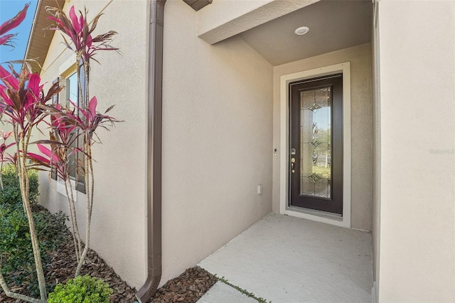 property entrance with stucco siding