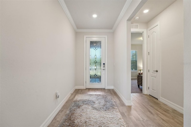 foyer featuring visible vents, light wood-style flooring, crown molding, and baseboards