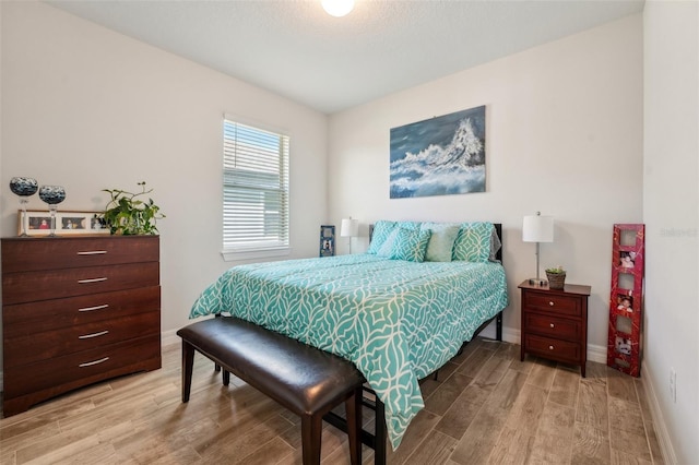 bedroom with light wood finished floors and baseboards