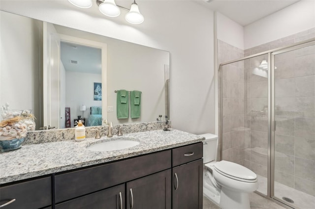 ensuite bathroom with visible vents, toilet, a stall shower, ensuite bathroom, and vanity