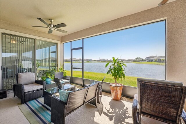 sunroom / solarium with a wealth of natural light, ceiling fan, and a water view