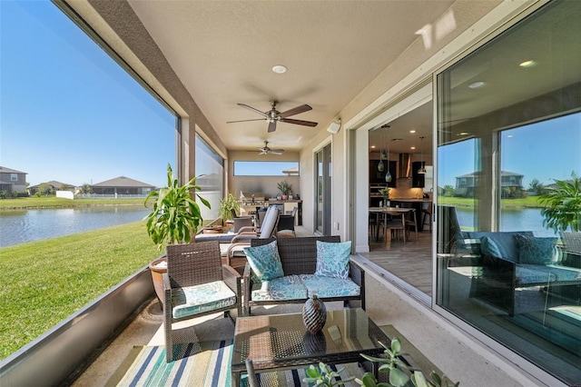 sunroom featuring a water view and ceiling fan