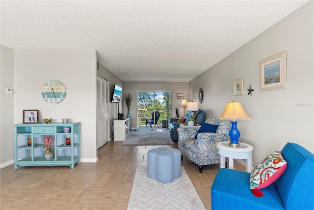 living room featuring a textured ceiling and baseboards