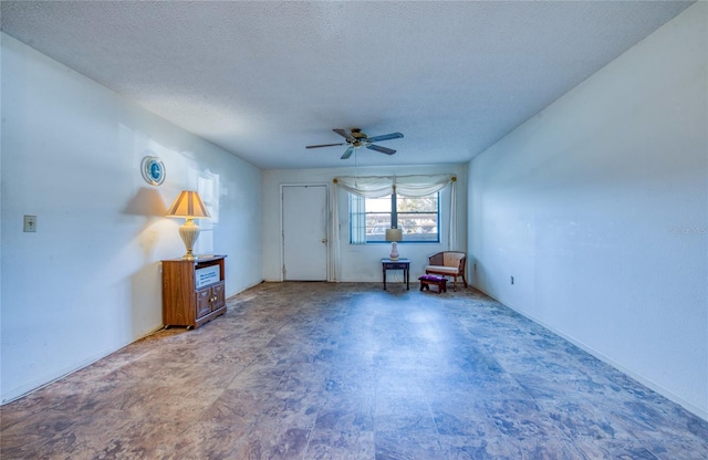 interior space with a textured ceiling and ceiling fan