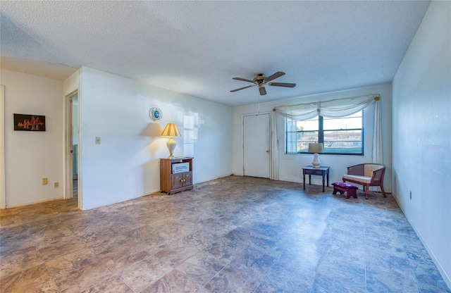 unfurnished room with a textured ceiling and a ceiling fan