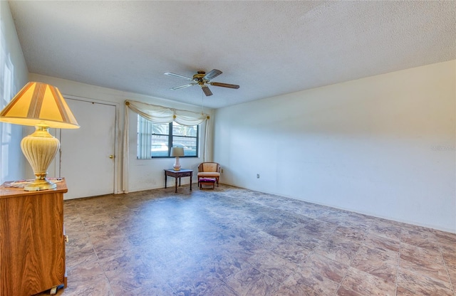 interior space with a textured ceiling and a ceiling fan