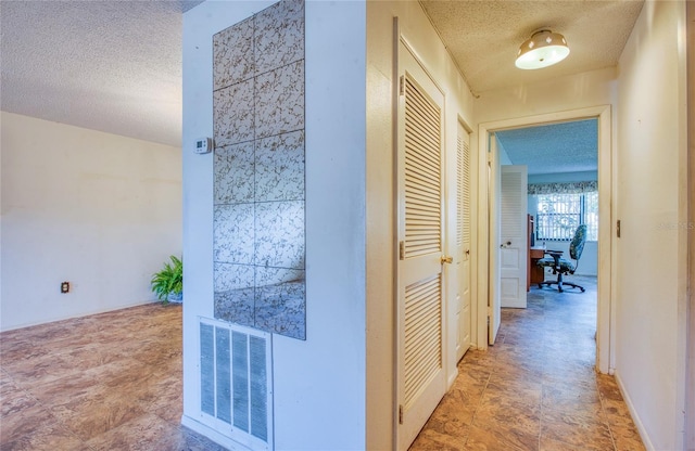 corridor featuring visible vents and a textured ceiling