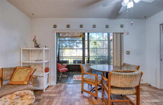 dining space featuring a textured ceiling and ceiling fan