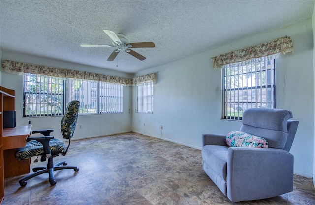 office space with a ceiling fan, a healthy amount of sunlight, baseboards, and a textured ceiling