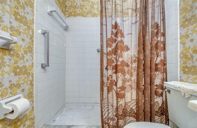 full bath with tiled shower and wallpapered walls