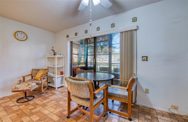 dining room featuring a textured ceiling, baseboards, and a ceiling fan