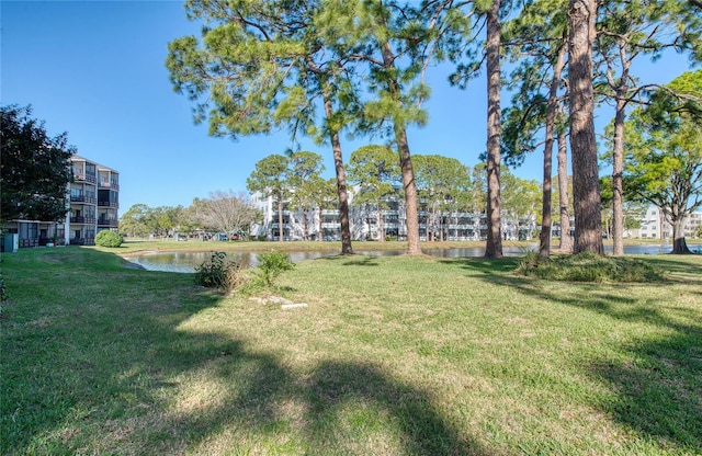 view of home's community with a lawn and a water view