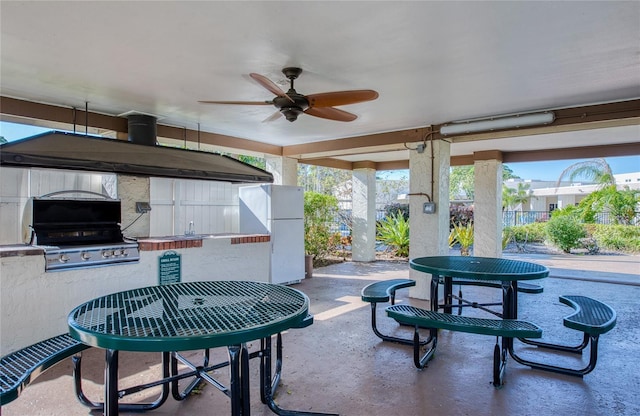 view of patio / terrace with area for grilling, a ceiling fan, fence, outdoor wet bar, and a grill