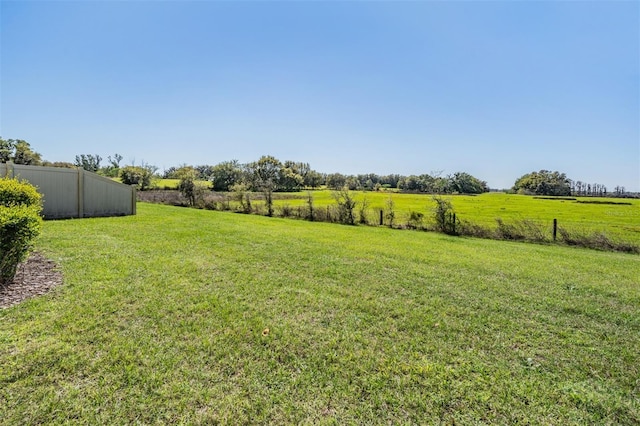 view of yard featuring a rural view and fence