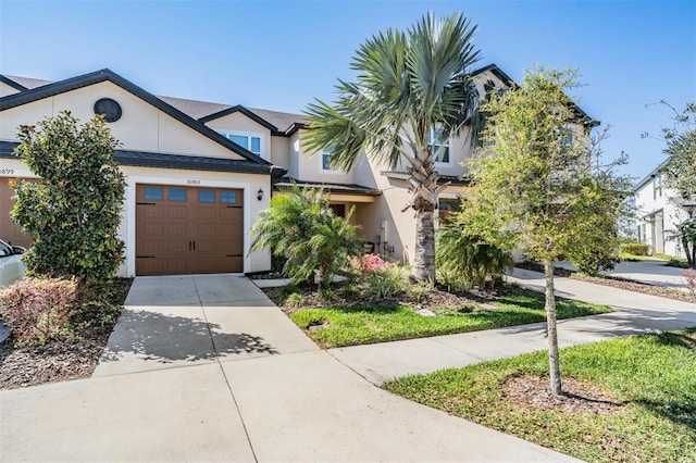 view of property with stucco siding, driveway, and an attached garage