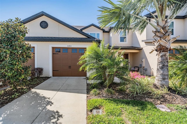 view of front of house featuring stucco siding, concrete driveway, and an attached garage