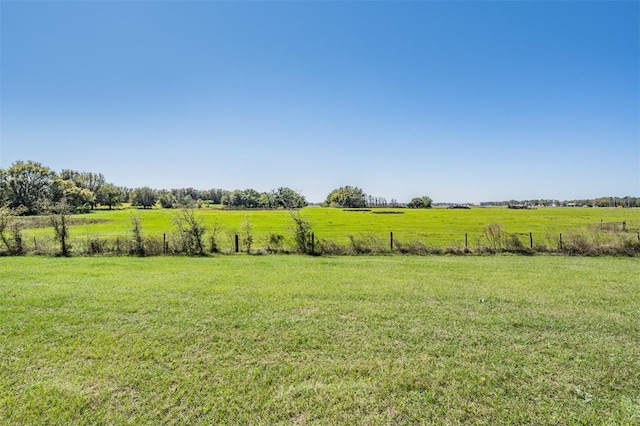 view of yard featuring a rural view and fence