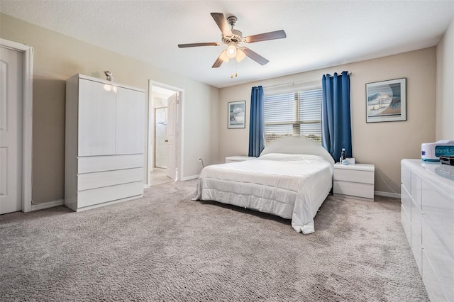 bedroom featuring ceiling fan, a textured ceiling, baseboards, and carpet floors