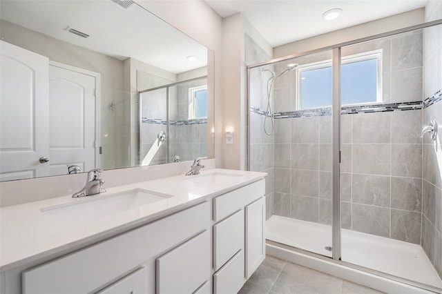 full bath with visible vents, a stall shower, and a sink