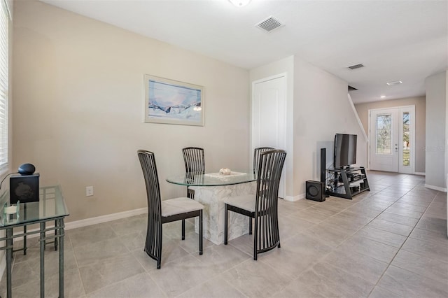 dining space featuring light tile patterned flooring, baseboards, and visible vents