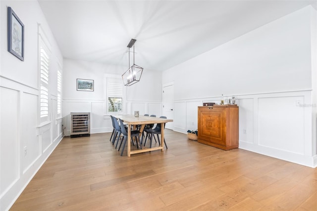 dining space with a decorative wall, heating unit, light wood-style floors, and a chandelier