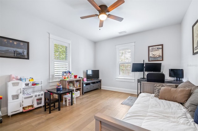 living area featuring ceiling fan, visible vents, baseboards, and wood finished floors