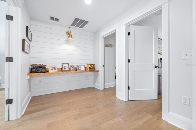 interior space with light wood-type flooring, visible vents, baseboards, and light countertops