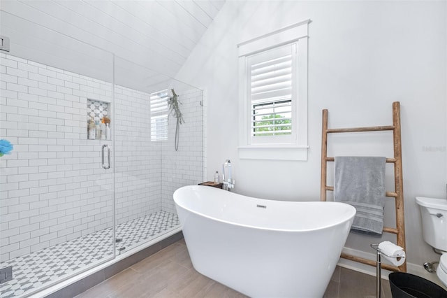 full bathroom featuring a freestanding bath, a shower stall, and vaulted ceiling