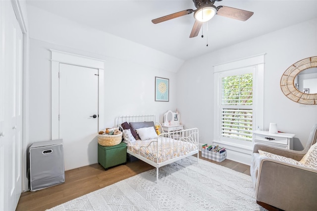 bedroom with ceiling fan, lofted ceiling, and wood finished floors