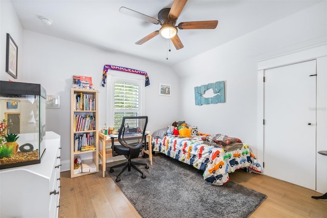 bedroom with vaulted ceiling, light wood finished floors, and ceiling fan