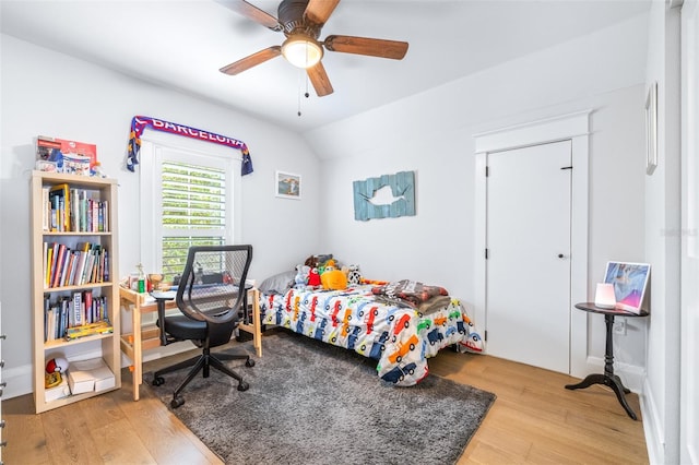 bedroom featuring a ceiling fan, lofted ceiling, and wood finished floors