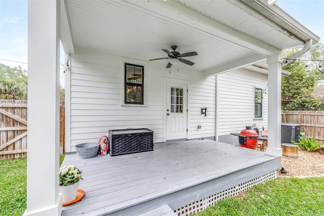 wooden terrace with cooling unit, ceiling fan, and fence