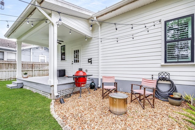 exterior space featuring a lawn, ceiling fan, and fence