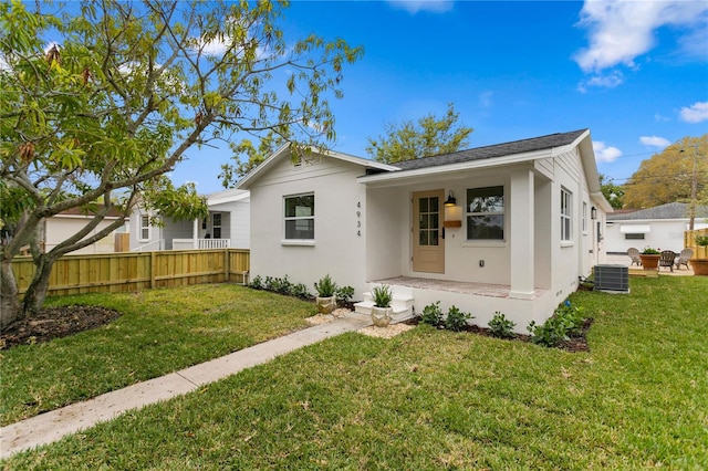 back of house featuring central air condition unit, a yard, fence, and stucco siding