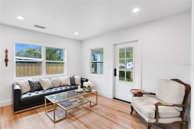 living area featuring recessed lighting, light wood-type flooring, and visible vents