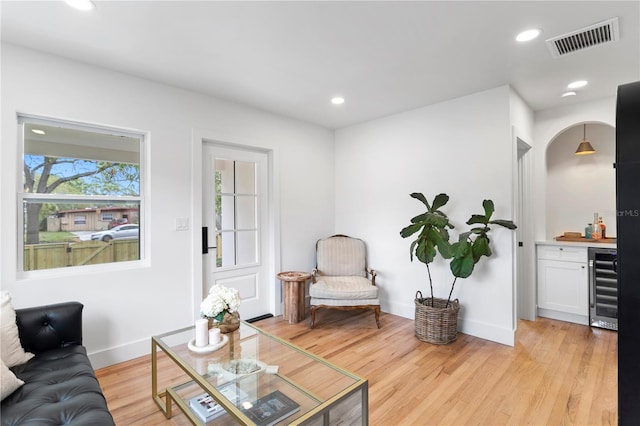 living area featuring beverage cooler, visible vents, light wood-style flooring, and recessed lighting