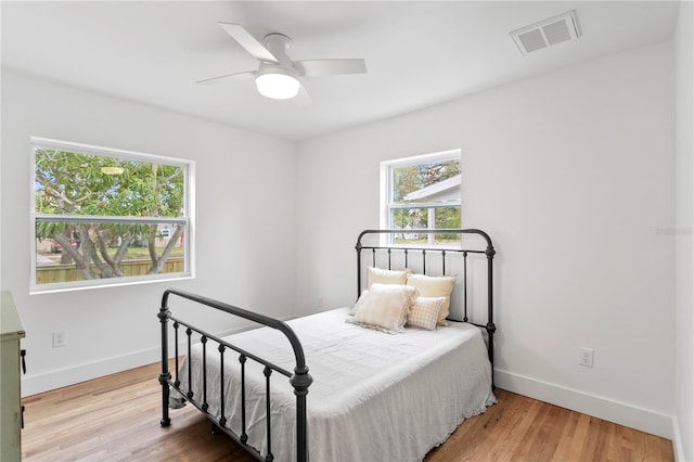 bedroom featuring visible vents, baseboards, and wood finished floors