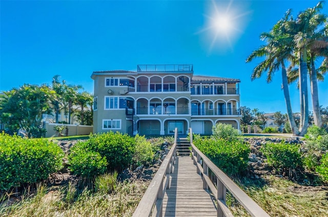 back of property featuring stairs and a balcony