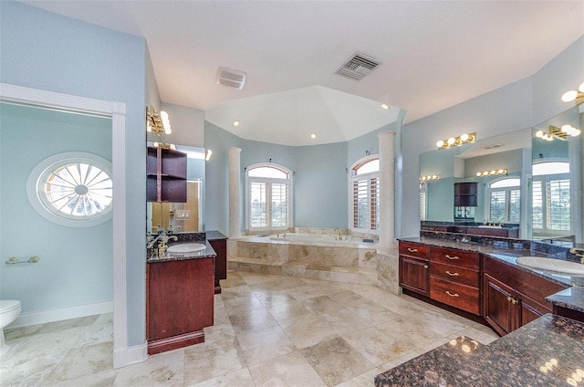 bathroom with visible vents, toilet, lofted ceiling, a garden tub, and a sink