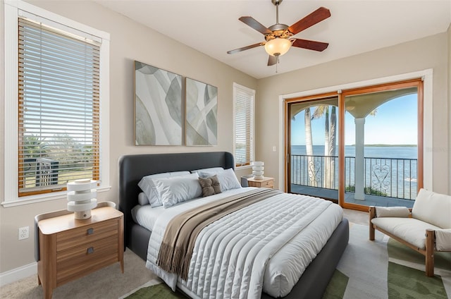 carpeted bedroom with baseboards, a water view, ceiling fan, and access to outside