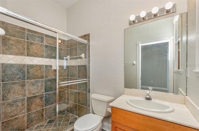 full bathroom featuring a shower stall, toilet, and vanity