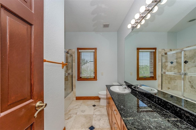 bathroom with visible vents, toilet, a healthy amount of sunlight, and vanity