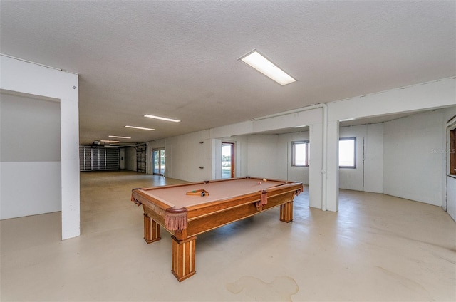 rec room featuring a textured ceiling, concrete flooring, and pool table