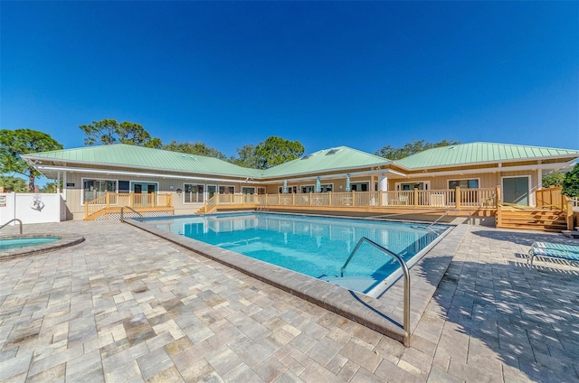 community pool featuring a patio, a deck, and fence